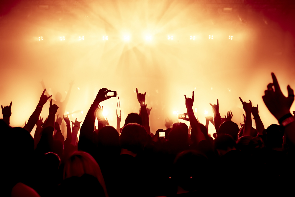 Silhouettes,Of,Concert,Crowd,In,Front,Of,Bright,Stage,Lights